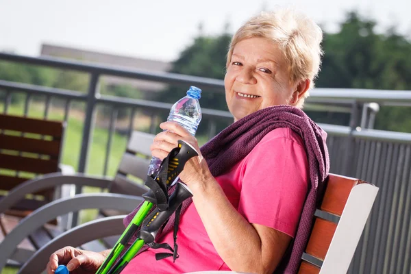 Senior vrouw rust na nordic-walking, sportieve levensstijl op oudere leeftijd — Stockfoto