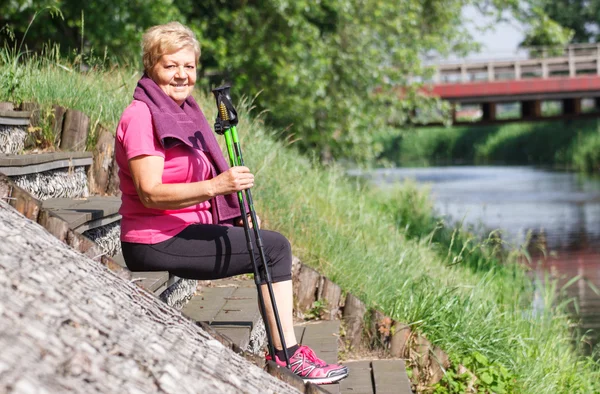Pihenő után a nordic walking, a folyóparti, sportos életmód idősebb nő — Stock Fotó
