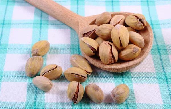 Orzechy pistacjowe z łyżką na obrus w kratkę, zdrowe jedzenie — Zdjęcie stockowe