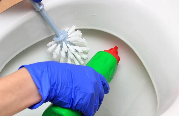 Ruka ženy v modré rukavice čištění záchodové mísy — Stock fotografie