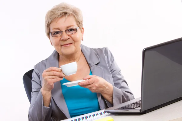 Femme d'affaires âgée buvant du thé ou du café au bureau, pause au travail — Photo