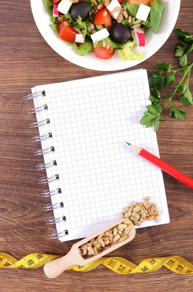 Świeża sałatka grecka z warzyw, centymetr i notatnik do pisania notatek, zdrowe odżywianie i odchudzanie koncepcja — Zdjęcie stockowe