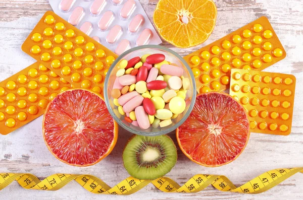 Natural fruits, centimeter and pills, slimming, choice between healthy nutrition and medical supplements