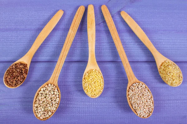 Various groats on wooden spoons, healthy food and nutrition — Stock Photo, Image