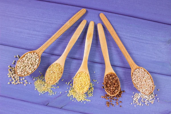 Various groats on wooden spoons, healthy food and nutrition — Stock Photo, Image