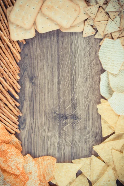 Foto vintage, Moldura de paus de pão, biscoitos e batatas fritas, comida não saudável, espaço de cópia para texto — Fotografia de Stock