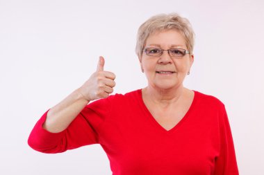 Happy smiling elderly woman showing thumbs up, positive emotions in old age