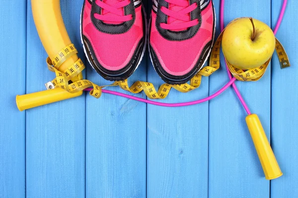 Par de zapatillas deportivas, frutas frescas y accesorios para fitness en tableros azules, espacio de copia para texto — Foto de Stock