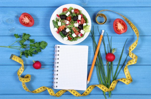 Sałatka Grecka z warzyw, centymetr i Notatnik dla notatki, zdrowej żywności i koncepcja odchudzanie — Zdjęcie stockowe