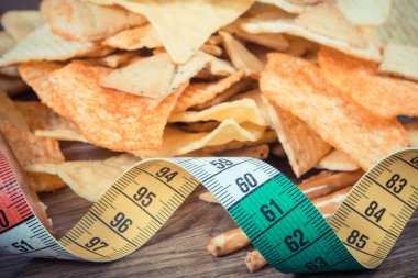 Vintage fotoğraf, tuzlu cips ve kurabiye, sağlıksız gıda ve zayıflama kavramı ile Santimetre