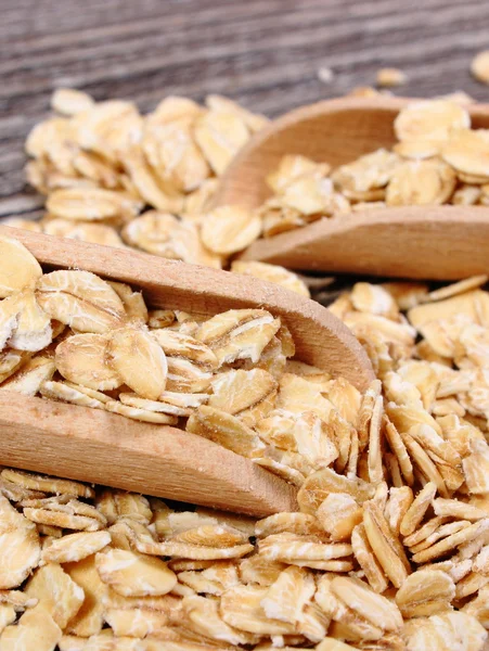 Copos de avena con cuchara sobre fondo de madera — Foto de Stock