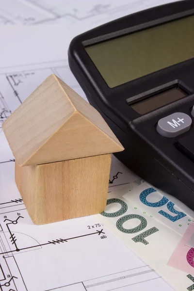 Casa di blocchi di legno e denaro polacco con calcolatrice sul disegno di costruzione, concetto di casa di costruzione — Foto Stock