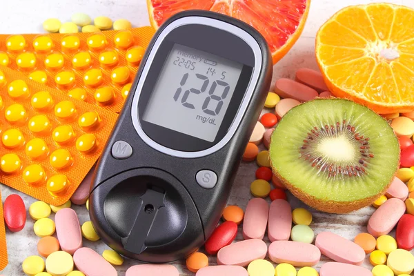 Glukometer mit Ergebnis, Früchte und bunte Pillen, Diabetes, gesunder Lebensstil und Ernährung — Stockfoto