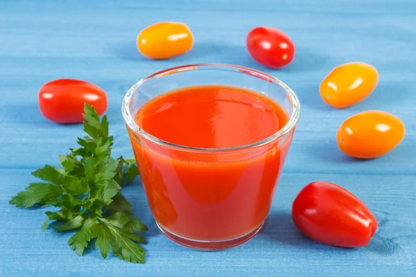 Tomatensap en groenten op een blauw bord, gezonde voeding — Stockfoto