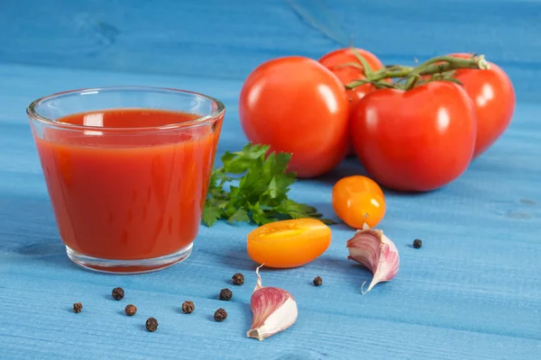 Tomatensap en groenten op een blauw bord, gezonde voeding — Stockfoto