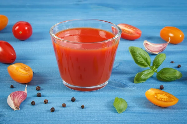 Tomatensap en fruit met specerijen op blauwe bord, gezonde voeding — Stockfoto