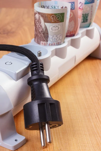 Rolls of polish currency money in electrical power strip and disconnected plug, energy costs — Stock Photo, Image