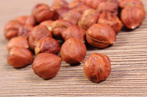 Heap of brown hazelnut on wooden table — Stock Photo, Image