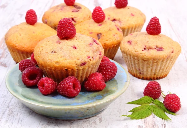 Fresh baked muffins with raspberries on old wooden background, delicious dessert — Stock Photo, Image