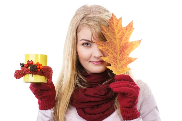 Ragazza sorridente in guanti tenendo decorato tazza di tè e foglia autunnale — Foto Stock