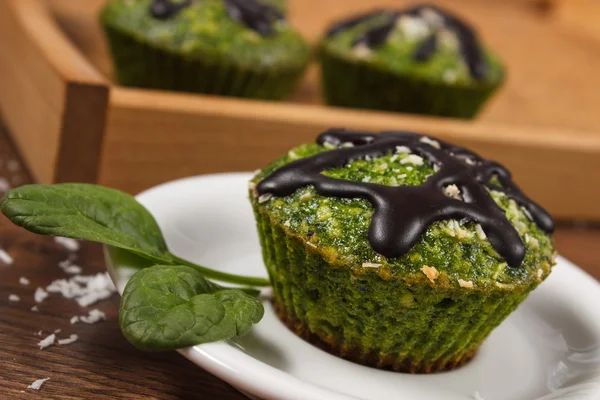 Muffins frescos com espinafre, coco desidratado e cobertura de chocolate, deliciosa sobremesa saudável — Fotografia de Stock