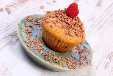 Ahududu ve ahşap zemin, lezzetli tatlı üzerine rendelenmiş çikolata ile pişmiş kek