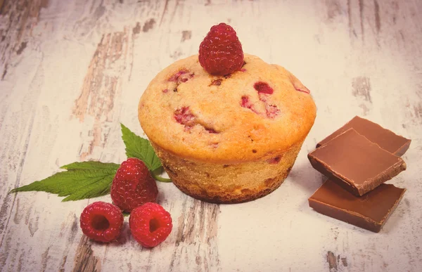 Vintage photo, Fresh baked muffins with raspberries and chocolate on wooden background, delicious dessert — Stock Photo, Image