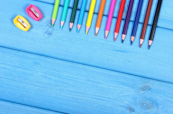 Lápices de colores y sacapuntas en pizarras azules, accesorios escolares, espacio de copia para texto —  Fotos de Stock