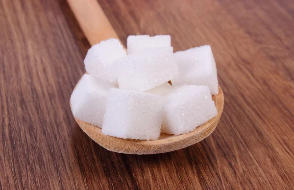 Cubes of sugar on wooden background, ingredient for cooking — Stock Photo, Image