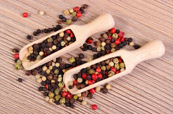 Verse gekleurde peper met lepel op houten achtergrond — Stockfoto