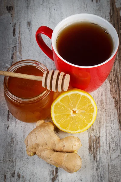 Свежий лимон с медом и чашкой чая на деревянном столе, здоровое питание — стоковое фото