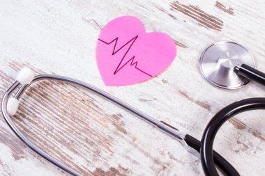 Kağıt kardiyogram çizgi ve ahşap arka plan, tıp ve sağlık kavramı stetoskop ile kalp