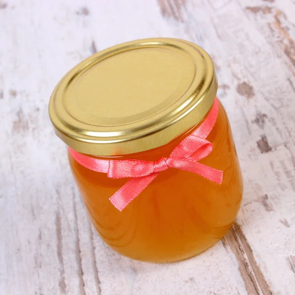 Miel orgánica fresca en frasco de vidrio sobre fondo de madera, nutrición saludable y fortalecimiento de la inmunidad — Foto de Stock