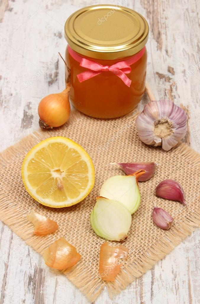 Onion, garlic, lemon and honey in glass jar, healthy nutrition and