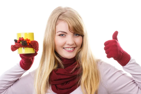 Glimlachend meisje in handschoenen met ingerichte kopje thee en laat duimen omhoog, herfst decoratie — Stockfoto