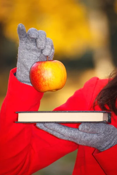 Rękę kobietę książki i apple w jesienny park — Zdjęcie stockowe