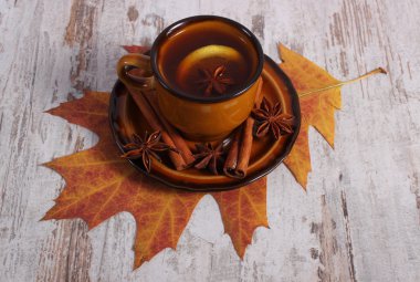 Limon, baharatlar ve ahşap arka plan üzerinde sonbahar yaprak çay