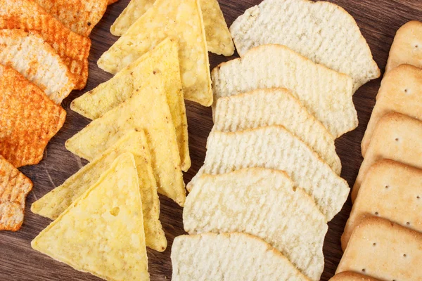 Galletas crujientes y patatas fritas saladas, concepto de comida poco saludable — Foto de Stock