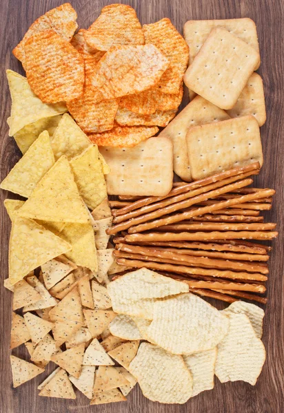 Heap of salted crisps, breadsticks and cookies, concept of unhealthy food — Stock Photo, Image