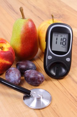 Glucose meter with medical stethoscope and fresh fruits, healthy lifestyle
