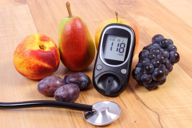 Glucose meter with medical stethoscope and fresh fruits, healthy lifestyle