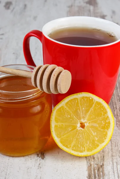 Färsk citron med honung och kopp te på träbord, hälsosam kost — Stockfoto