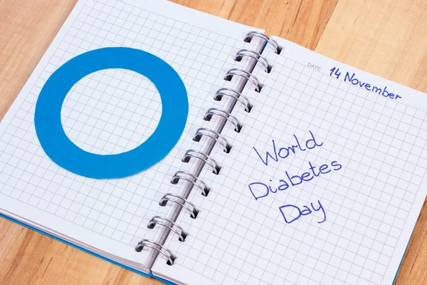 Światowego dnia cukrzycy napisane w notatnik i niebieski okrąg, symbol cukrzycy — Zdjęcie stockowe