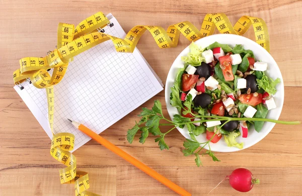 Salade grecque fraîche avec légumes, centimètre et bloc-notes pour écrire des notes, une alimentation saine et un concept minceur — Photo