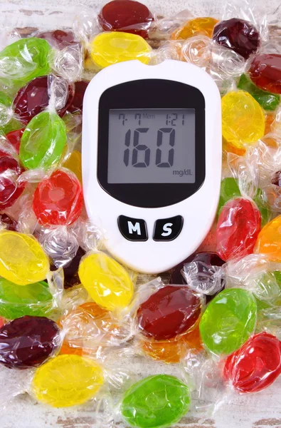 Glukosmätare och färgglada godis, diabetes, minskning äta godis — Stockfoto