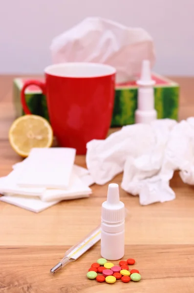 Tabletták és az orr csepp a megfázás, használt zsebkendők és forró teát citrommal — Stock Fotó