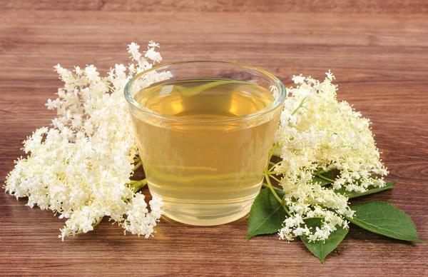 Fresco jugo sano y flores de saúco en tablero rústico — Foto de Stock