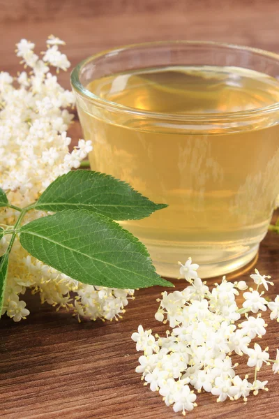 Fresco jugo sano y flores de saúco en tablero rústico — Foto de Stock