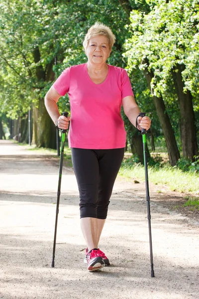 Idősek magas rangú nő gyakorló nordic walkingra, sportos életmód idős korban — Stock Fotó