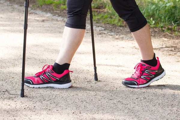 Piernas de anciana mayor practicando senderismo nórdico, estilos de vida deportivos en la vejez — Foto de Stock